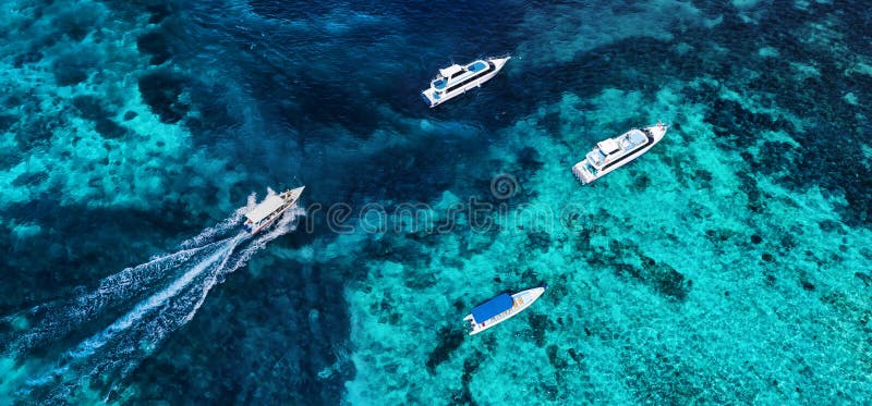 Boats on the water surface from top view. Azure water background from drone. Summer seascape from air.