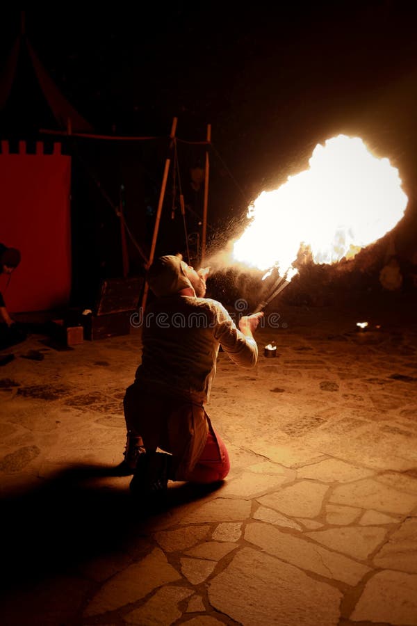 Bobo da corte que come o fogo em uma mostra medieval imagens de stock Bobo da corte que come o fogo em uma mostra medieval imagens de stock