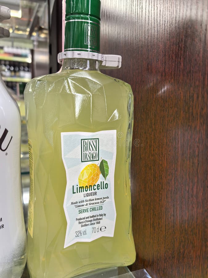 Refreshing limoncello bottle displayed on a wooden shelf in a store stock image