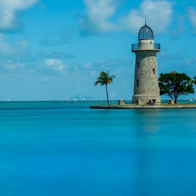 Boca Chita Lighthouse Reflecting in Blue Water with Miami skyline in background