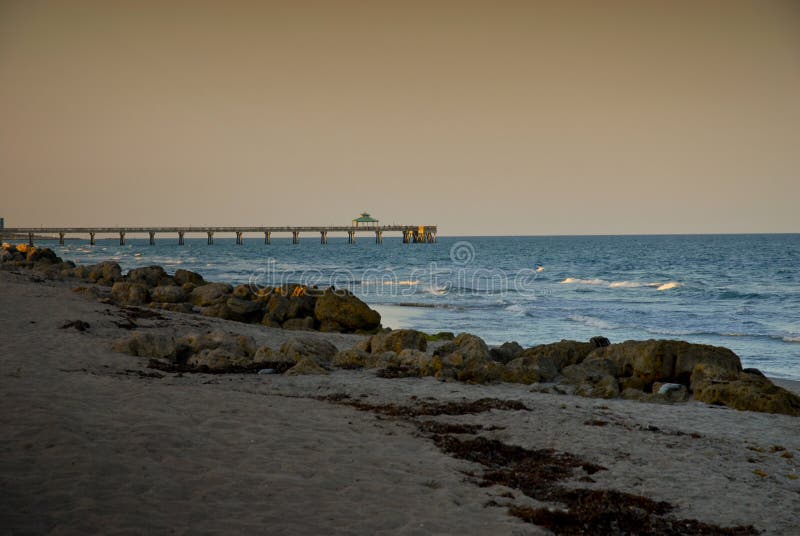 Rock and sandy beaches in Boca Florida. yellowish skies and blue ocean with breaking waves. Rock and sandy beaches in Boca Florida. yellowish skies and blue ocean with breaking waves.