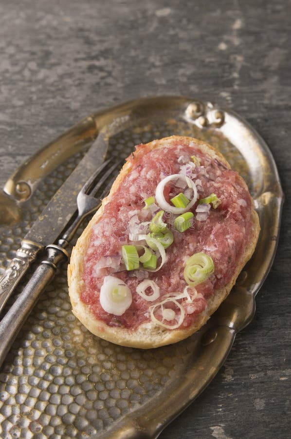 Bocadillo con la carne tartare en bandeja del vintage con la bifurcación y el cuchillo imagenes de archivo