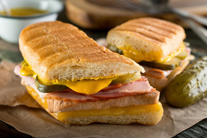 An authentic cuban sandwich on pressed medianoche bread with pork, ham, cheese, pickle, and mustard. An authentic cuban sandwich on pressed medianoche bread with pork, ham, cheese, pickle, and mustard.