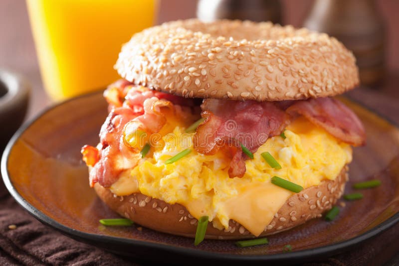Bocadillo del desayuno en el panecillo con queso del tocino del huevo fotografía de archivo Bocadillo del desayuno en el panecillo con queso del tocino del huevo fotografía de archivo
