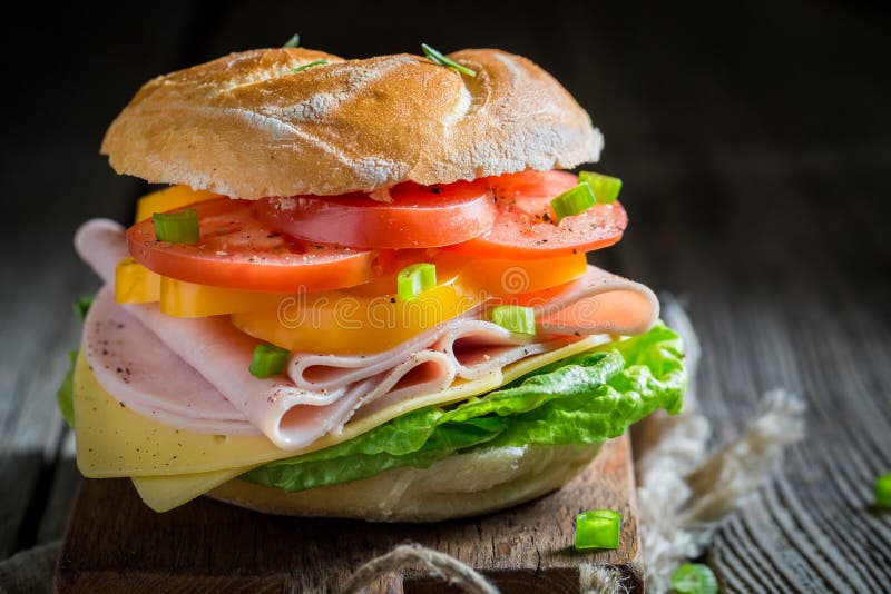 Bocadillo quebradizo con las verduras y el jamón por la mañana imagenes de archivo Bocadillo quebradizo con las verduras y el jamón por la mañana imagenes de archivo