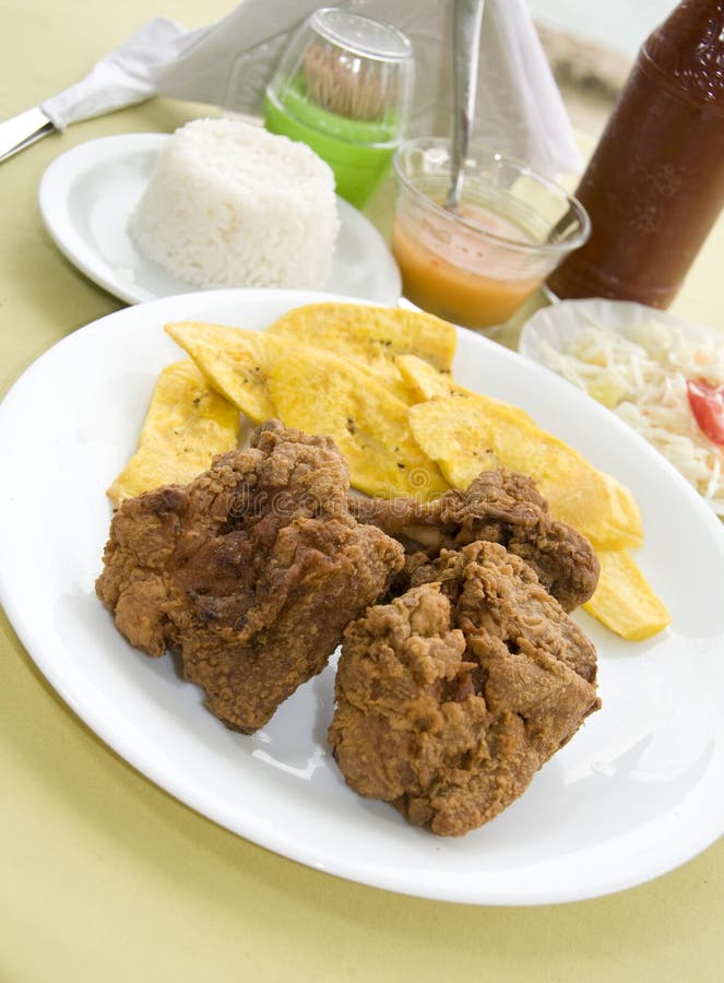 Chicken bocas and plantain tostones patacones fried banana chips shredded cabbage tomatoes typical meal photographed in Nicaragua. Chicken bocas and plantain tostones patacones fried banana chips shredded cabbage tomatoes typical meal photographed in Nicaragua