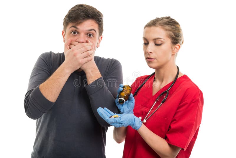 Bocca paziente maschio della copertura per la presa delle pillole femminili di medico immagine stock libera da diritti Bocca paziente maschio della copertura per la presa delle pillole femminili di medico immagine stock libera da diritti