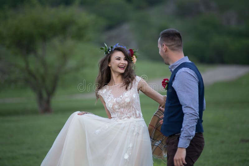 Boda Novia y novio que llevan a cabo las manos y el paseo en el campo verde imagenes de archivo