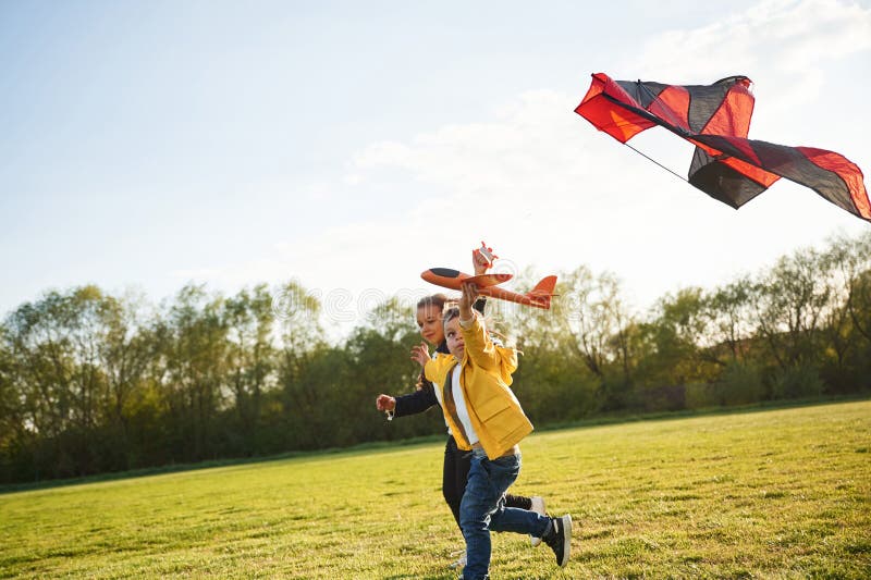 Bodenliegen. Kleiner Junge spielt mit Spielzeugflugzeug auf dem Sommerfeld lizenzfreie stockfotos