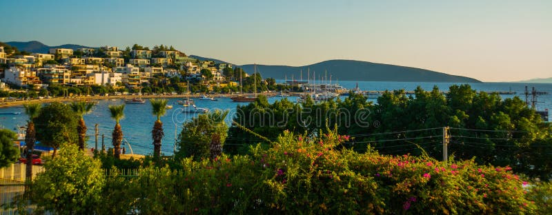 BODRUM, MUGLA, TURKEY: View of the white houses and the beach and the mountains in the city of Bodrum on a sunny day. BODRUM, MUGLA, TURKEY: View of the white houses and the beach and the mountains in the city of Bodrum on a sunny day.