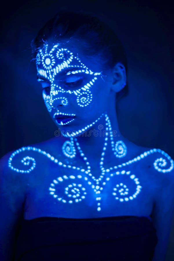 Body art on the body and hand of a girl glowing in the ultraviolet light royalty free stock photography Body art on the body and hand of a girl glowing in the ultraviolet light royalty free stock photography