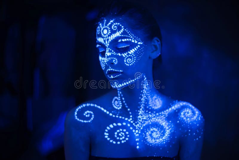 Body art on the body and hand of a girl glowing in the ultraviolet light royalty free stock photo Body art on the body and hand of a girl glowing in the ultraviolet light royalty free stock photo