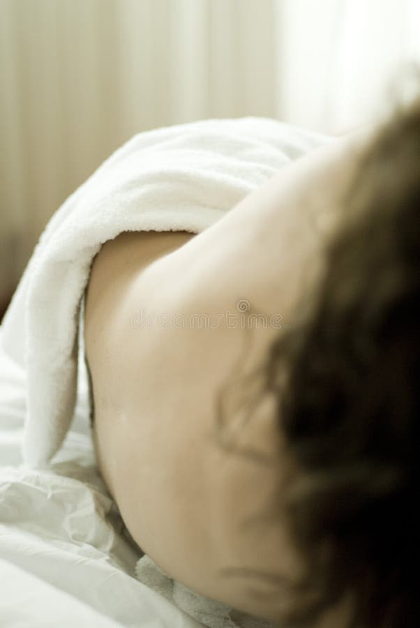 Body of nude woman on bed stock photos
