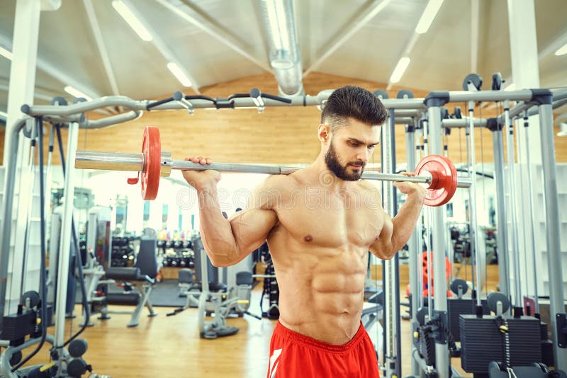 Bodybuilder with a Bar Barbell Makes Exercises in the Gym Stock Image