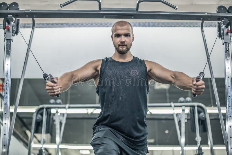 Bodybuilder caucasien beau brutal établissant dans le coffre de formation de gymnase pompant des withdumbbells de muscles pectora image libre de droits Bodybuilder caucasien beau brutal établissant dans le coffre de formation de gymnase pompant des withdumbbells de muscles pectora image libre de droits