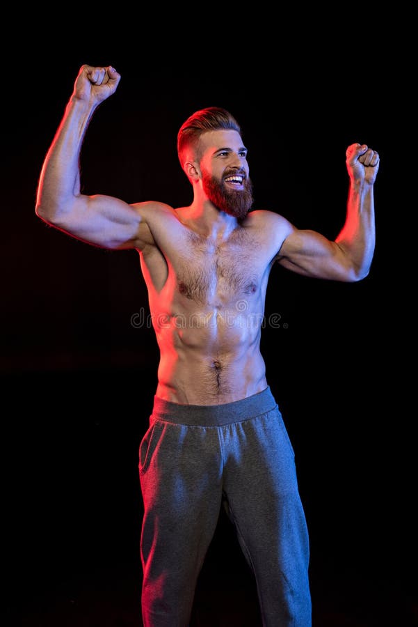 Bodybuilder Celebrating Triumph Isolated on Black with Dramatic