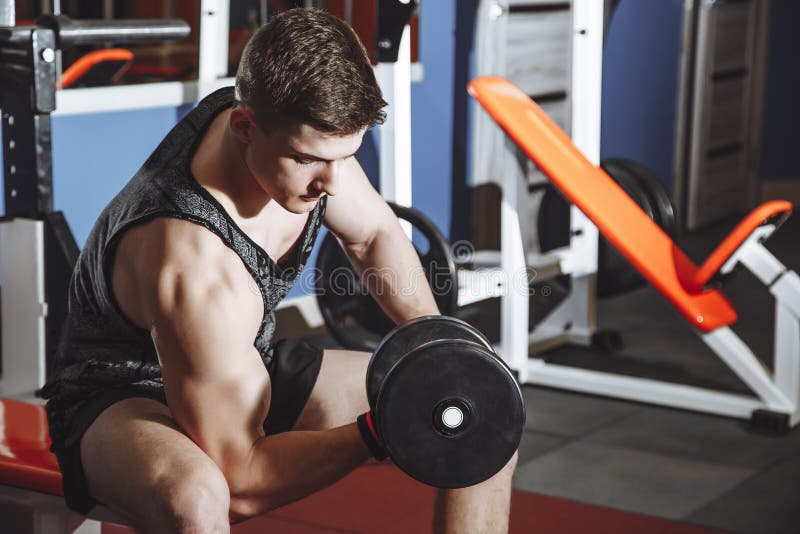 Bodybuilder die met domoorgewichten bij de gymnastiek uitwerken Mensenbodybuilder die oefeningen met domoor doen Geschiktheids sp stock fotografie Bodybuilder die met domoorgewichten bij de gymnastiek uitwerken Mensenbodybuilder die oefeningen met domoor doen Geschiktheids sp stock fotografie