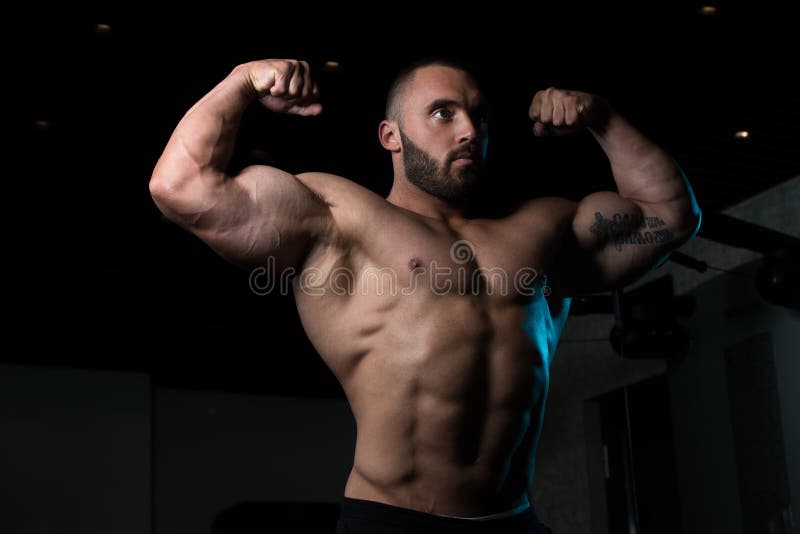 Bodybuilder mężczyzna pozuje w gym