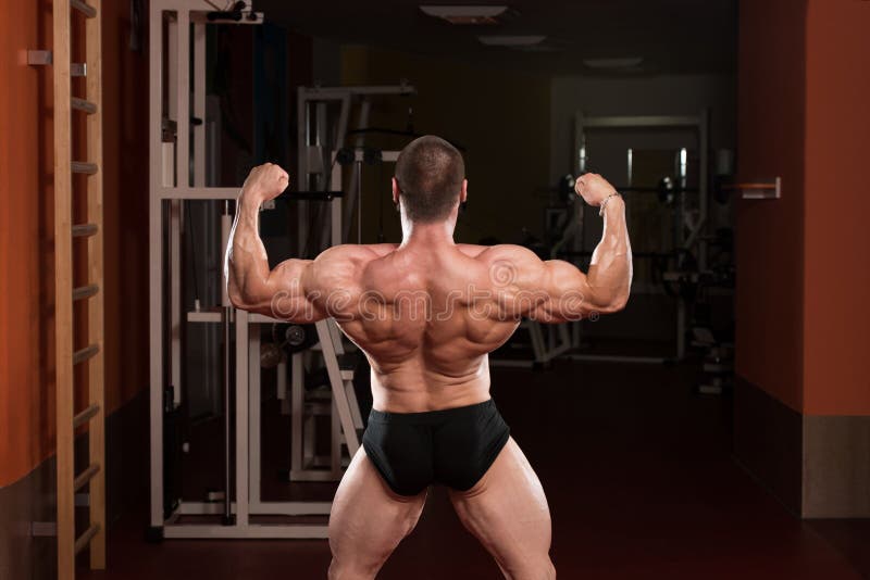 Male muscular athlete poses in studio, back view - Stock Photo [81799783] -  PIXTA