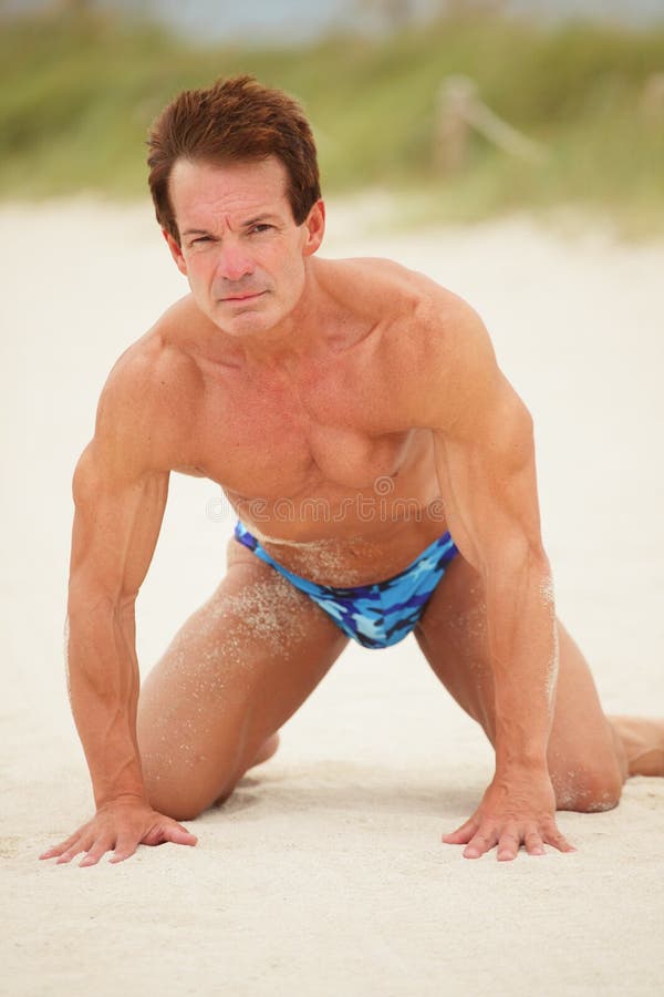 Bodybuilder posing on the sand