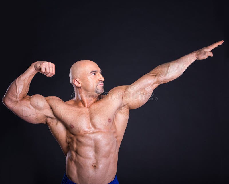 Bodybuilder is posing, showing his muscles. Force, relief, muscle, courage, virility, bodybuilder, bodybuilding. The concept of a healthy lifestyle.