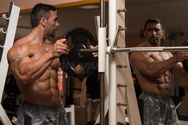 Bodybuilder Putting Weights on Bar in Gym Stock Photo Image of