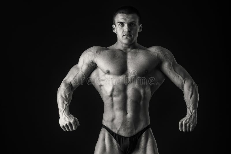 Bodybuilder showing his muscles. Muscles of the back, arms, torso. Muscular man in great shape. The concept of bodybuilding.