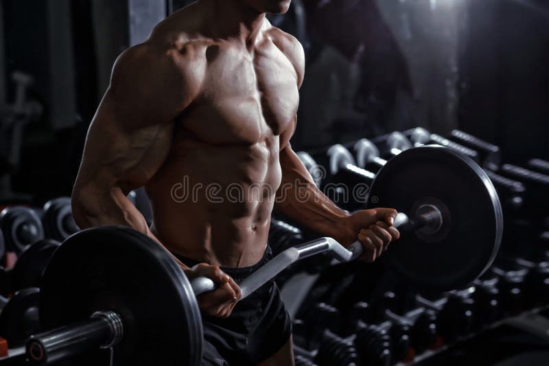 Bodybuilder stażowi bicepsy z barbell w gym