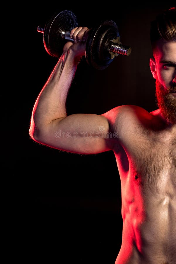 Bodybuilder Training with Dumbbell Isolated on Black with Dramatic