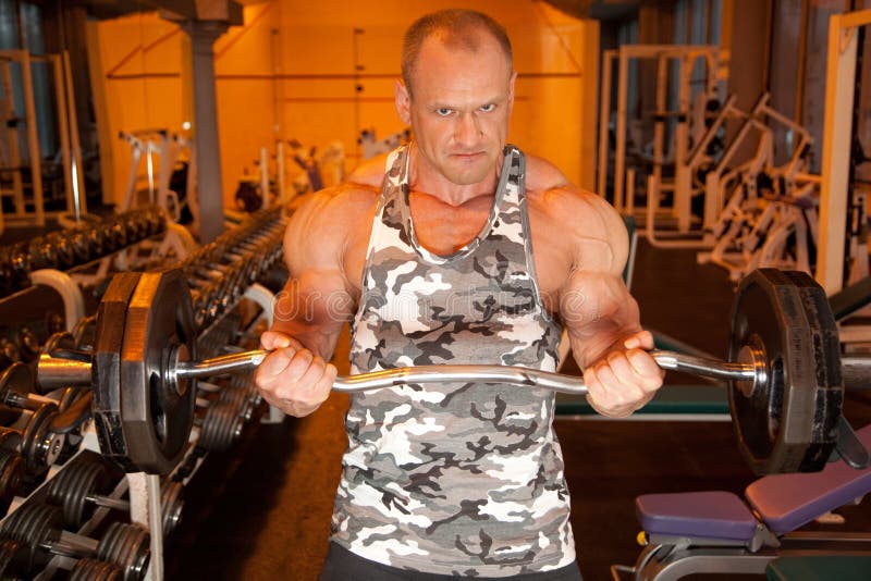 Bodybuilder with barbell in training room. Bodybuilder with barbell in training room