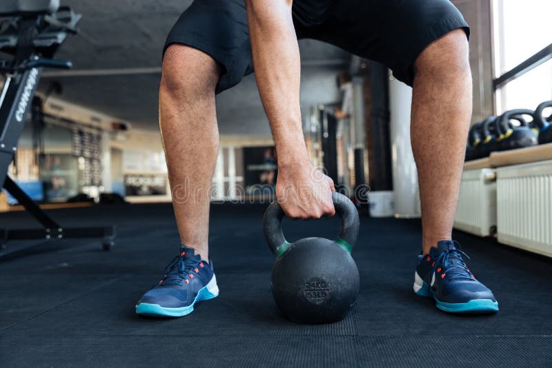 Bodybuilder Using Kettlebell in His Workout at the Gym Stock Photo