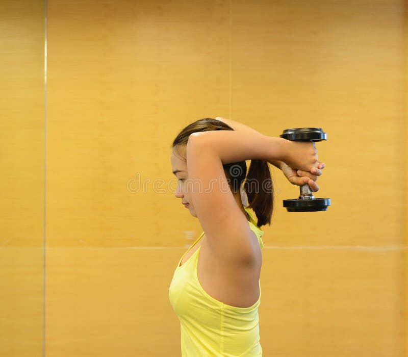 bodybuilding Starke Sitzfrau, die mit Dummköpfen trainiert lizenzfreie stockbilder bodybuilding Starke Sitzfrau, die mit Dummköpfen trainiert lizenzfreie stockbilder