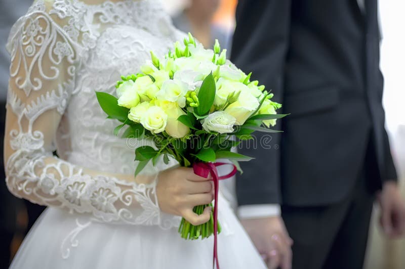 Boeket van rozen in de handen van de bruid met ondiepe diepte van gebied royalty-vrije stock fotografie Boeket van rozen in de handen van de bruid met ondiepe diepte van gebied royalty-vrije stock fotografie