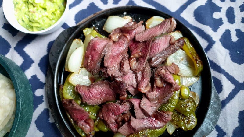 Boeuf fajita mexicaine fer plate sizzler vue de dessus avec guacamole banque de vidéos