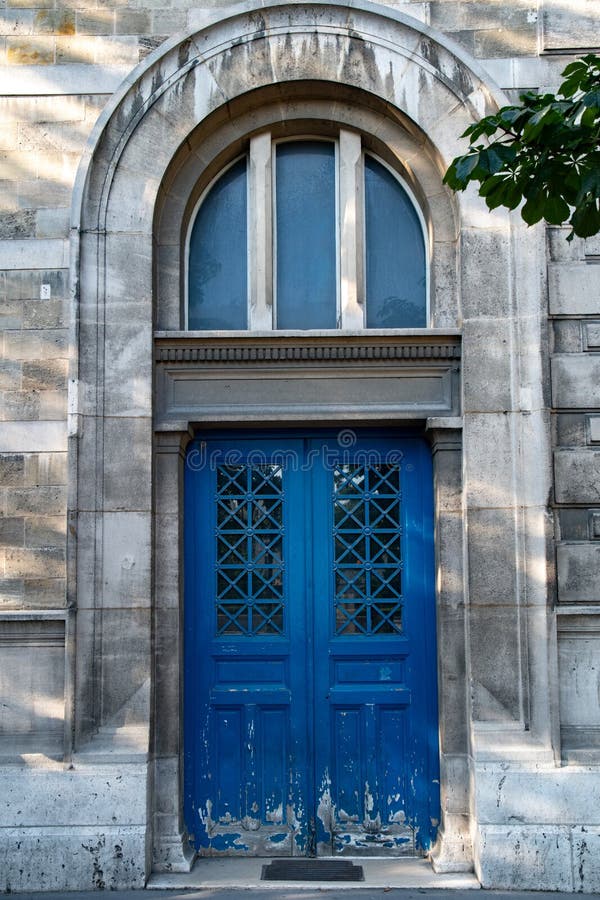Bogentür mit Fenster des Altbaus in Paris Frankreich Hölzerner blauer gemalter Eingang der Weinlese mit abblätternder Farbe stockfotografie Bogentür mit Fenster des Altbaus in Paris Frankreich Hölzerner blauer gemalter Eingang der Weinlese mit abblätternder Farbe stockfotografie