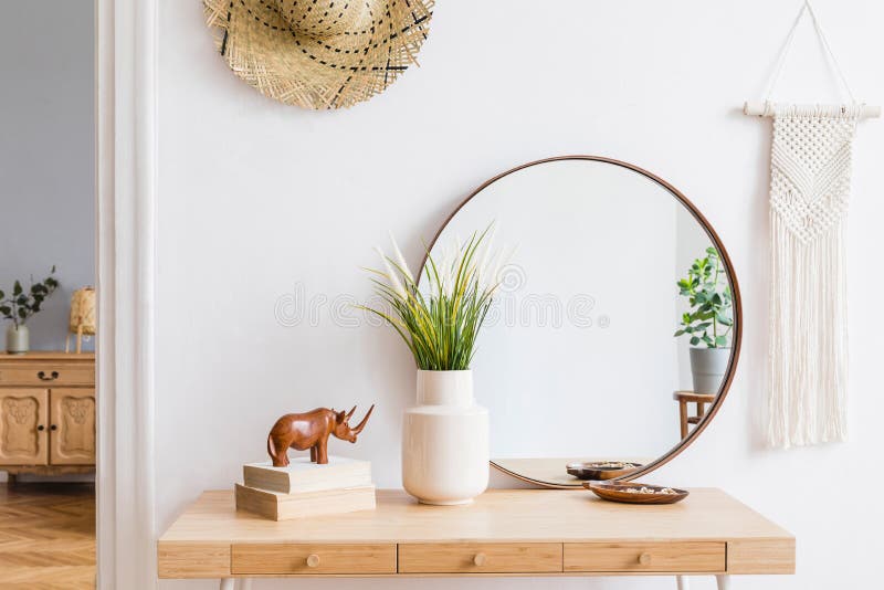 Boho interior design of home office with large, round mirror.