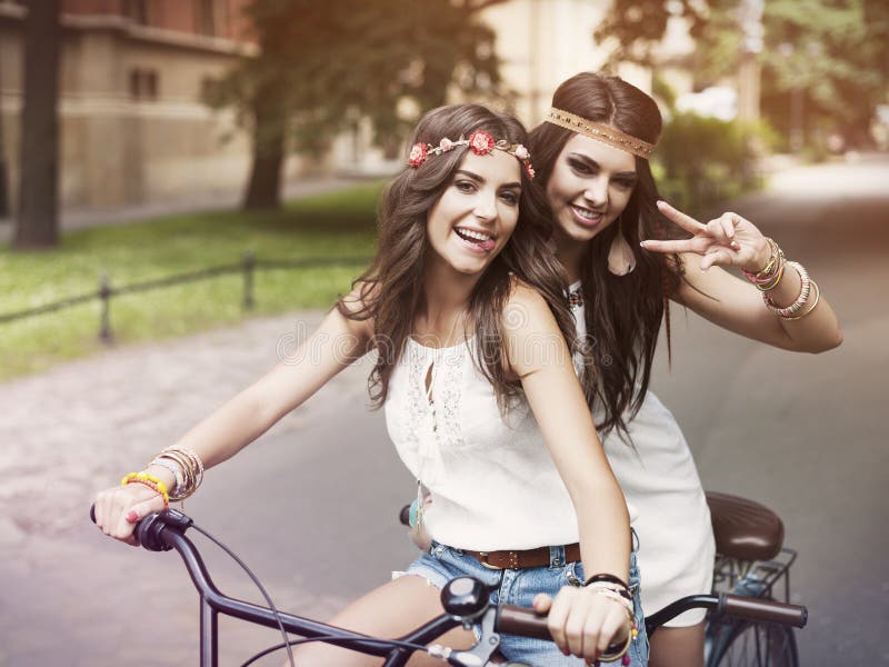 Portrait of funny boho girls on the tandem bicycle. Portrait of funny boho girls on the tandem bicycle