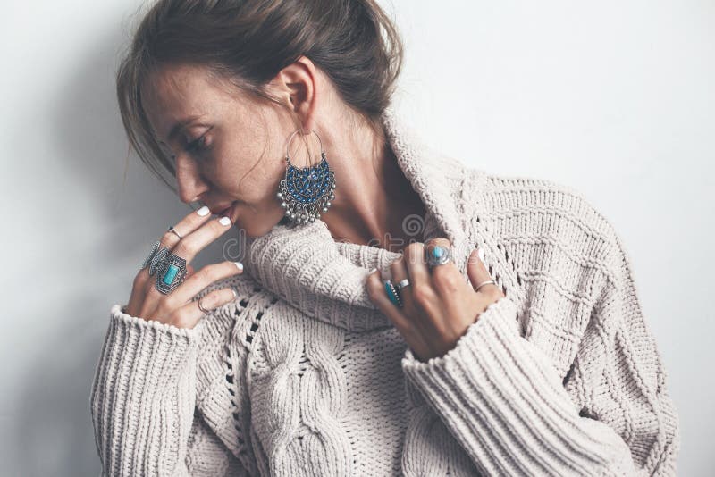 Boho jewelry and woolen sweater on model. Boho jewelry on model: ethnic stone rings and earrings. Beautiful woman wearing warm woolen sweater and fashion royalty free stock image Boho jewelry and woolen sweater on model. Boho jewelry on model: ethnic stone rings and earrings. Beautiful woman wearing warm woolen sweater and fashion royalty free stock image