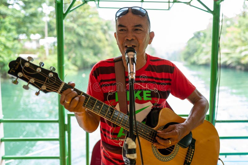 Bohol, Filippinerna - 11 september 2019: En sångare på en flytande turistbåt och restaurang på floden Bohol royaltyfria foton