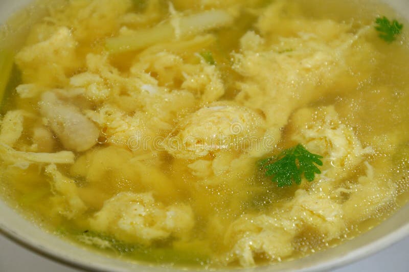 Boiled egg with chicken clear soup in bowl