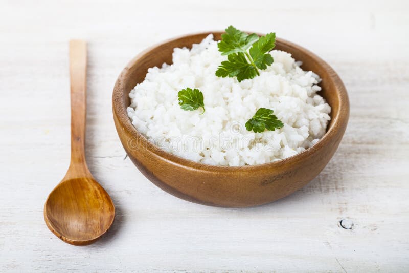 Boiled rice in a wooden bowl and spoon.