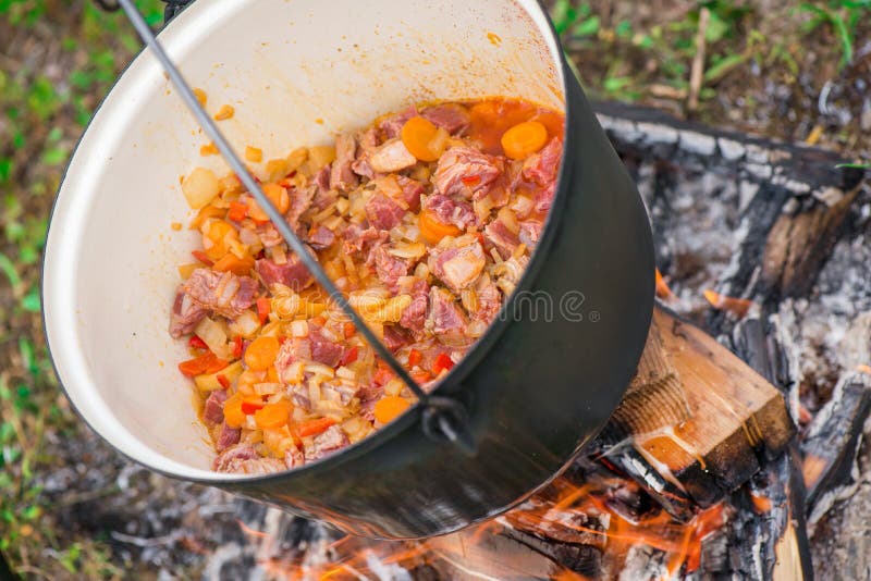 Boiling, hot goulash soup with meat, paprika, potatoes, onion, carrots is the traditional dish of Hungarian cuisine. Meat stew being prepared in crock pot on stock photos