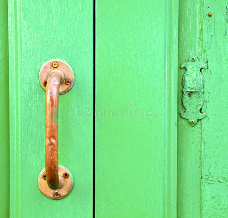 Spain brass knocker lanzarote abstract door wood in the green. Spain brass knocker lanzarote abstract door wood in the green