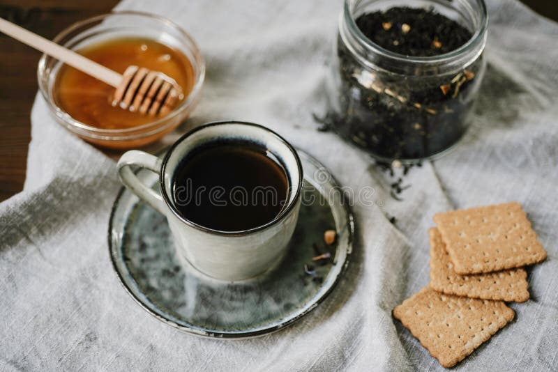 Boisson et bonbons chauds Tasse, miel, biscuits et feuilles de thé au-dessus de t photos libres de droits Boisson et bonbons chauds Tasse, miel, biscuits et feuilles de thé au-dessus de t photos libres de droits