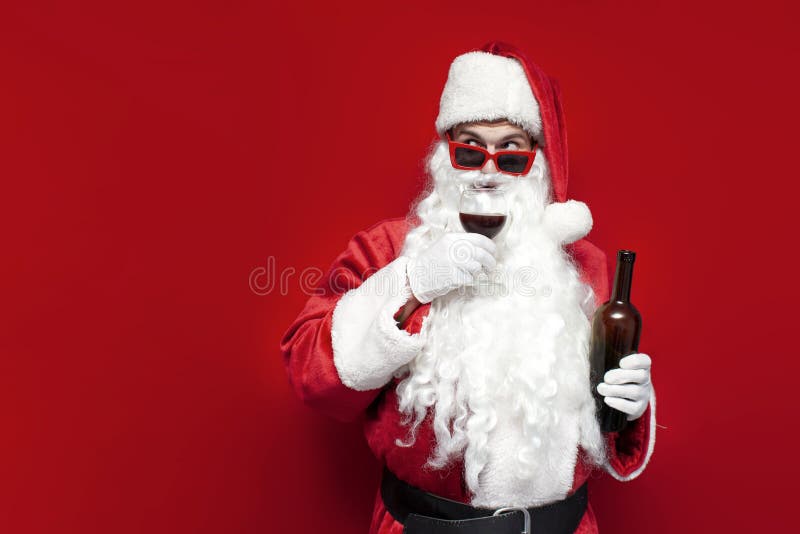 Boissons santa claus dans le chapeau et verres festifs boissons vin du verre sur fond rouge images stock