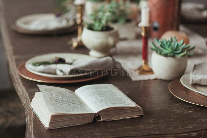 Boka att ligga på tabellen som tjänas som med suckulenter, stearinljus, lantliga plattor Läsa i kafébegrepp