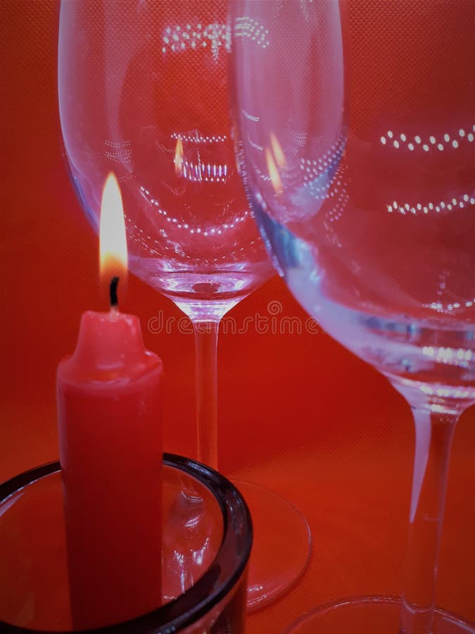 Bokeh effect, glass / crystal glasses and a candlestick with a red candle on a red abstract background royalty free stock image Bokeh effect, glass / crystal glasses and a candlestick with a red candle on a red abstract background royalty free stock image