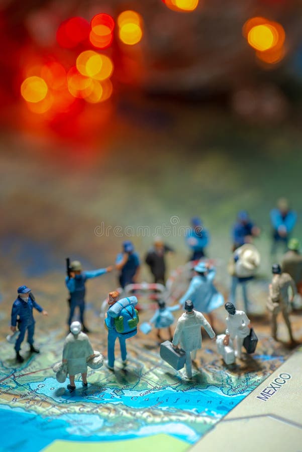 Bokeh light - Miniature toy people concept US border patrols against a group of migrant from Mexico