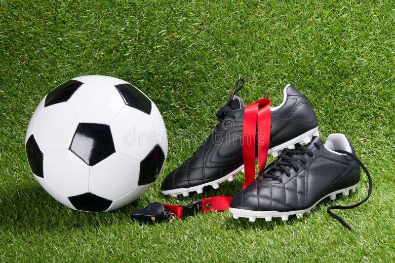 Bola, botas e assobio de futebol para o árbitro, na perspectiva da grama foto de stock Bola, botas e assobio de futebol para o árbitro, na perspectiva da grama foto de stock