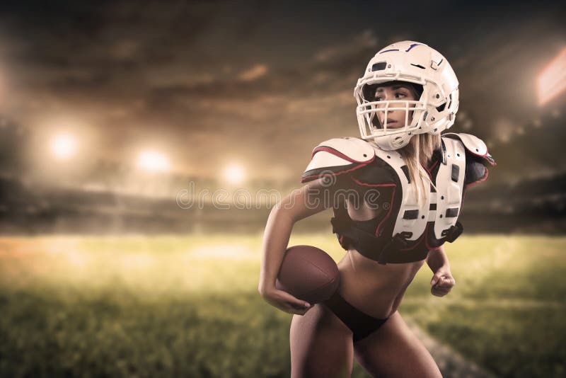 Bola da terra arrendada do jogador da mulher do futebol americano na opinião do panorama do estádio foto de stock royalty free Bola da terra arrendada do jogador da mulher do futebol americano na opinião do panorama do estádio foto de stock royalty free